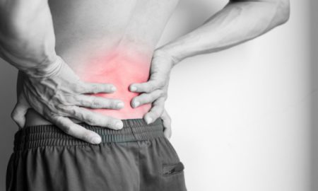 Athletic man's back pain isolated in black and white